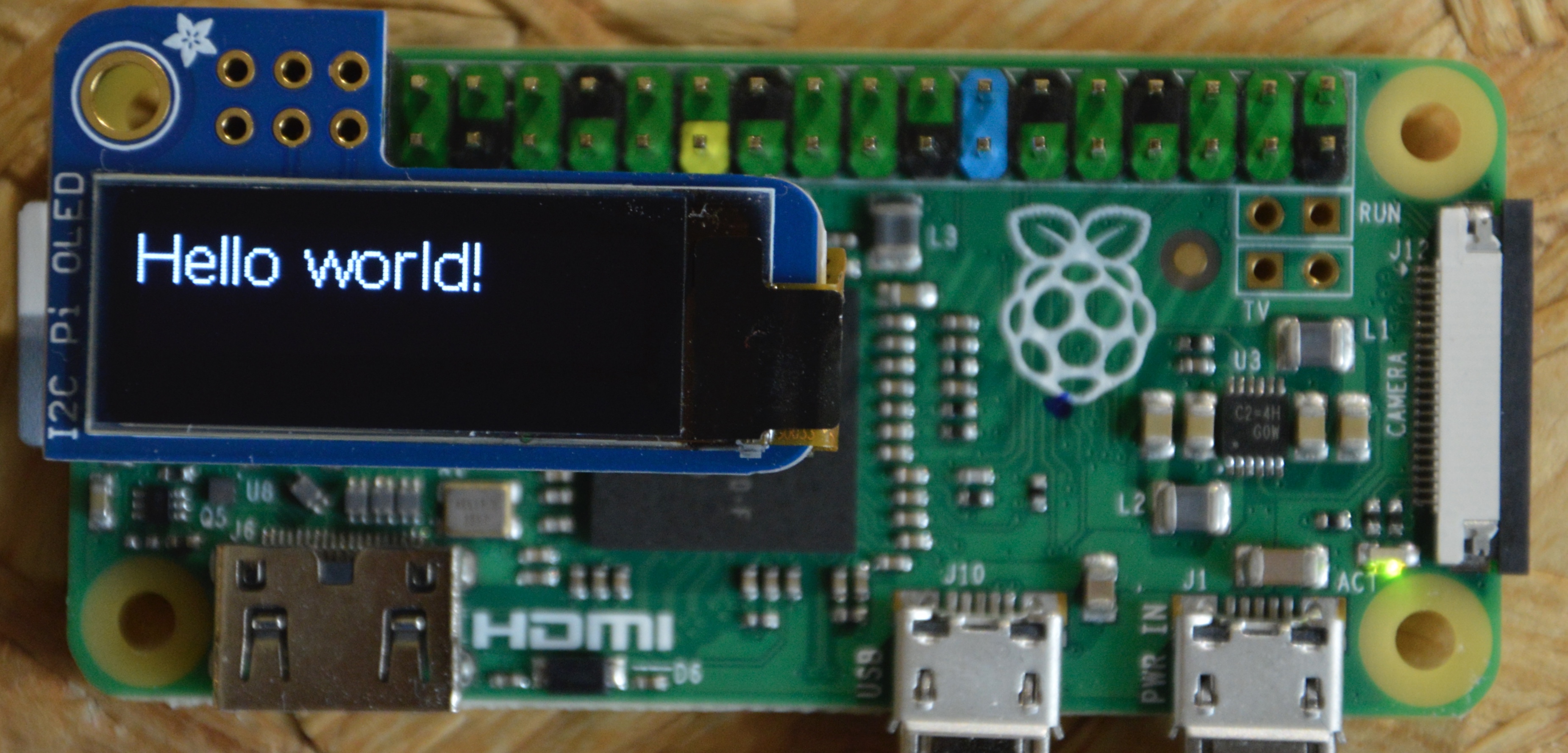 Raspberry Pi running SwiftyOLED and SwiftyGFX on an OLED display showing Hello world
